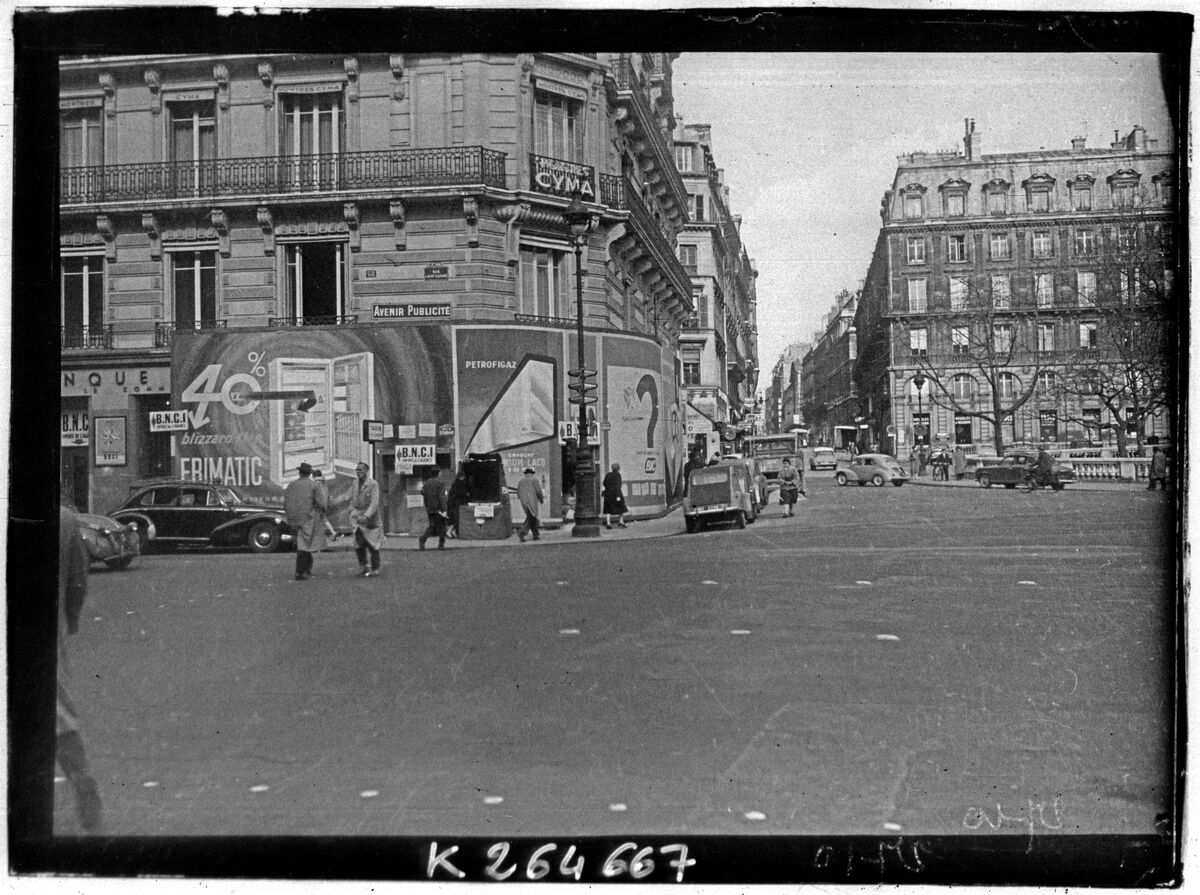 Affiches et panneaux publicitaires dans une rue parisienne vers 1950