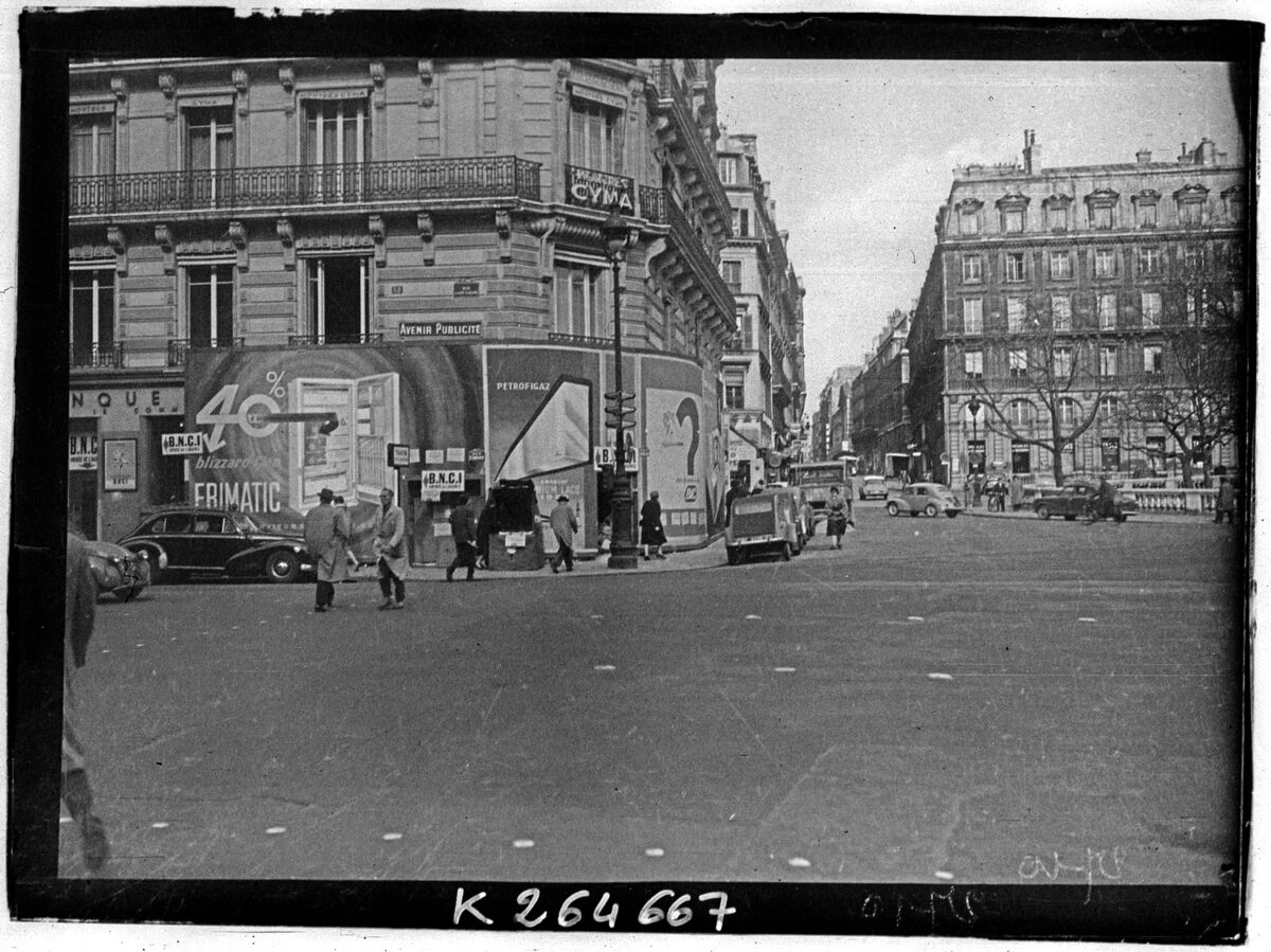 Panneaux publicitaires et circulation automobile dans Paris vers 1950